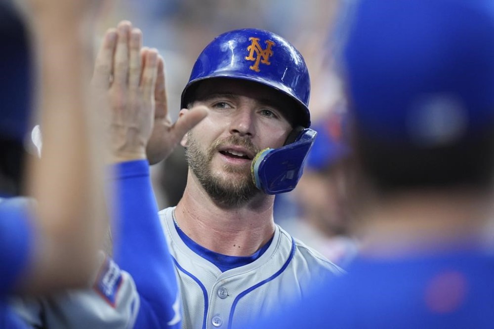 New York Mets' Pete Alonso celebrates with teammates after he scored on a sacrifice fly ball hit by Luis Torrens during the fourth inning of a baseball game against the Miami Marlins, Sunday, July 21, 2024, in Miami. (AP Photo/Wilfredo Lee)