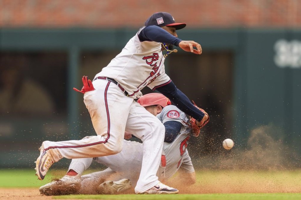 Atlanta Braves second baseman Ozzie Albies, top, attempts to tag out St. Louis Cardinals Michael Siani, bottom, in the eighth inning of a baseball game, Sunday, July 21, 2024, in Atlanta. (AP Photo/Jason Allen)