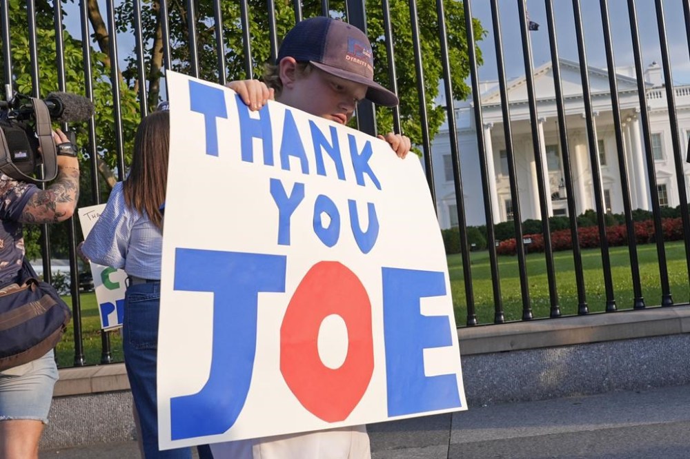 Hugh Kieve, 10, of Washington, holds a sign outside the White House in Washington, Sunday, July 21, 2024, as he and his family come out to show support for President Joe Biden. Biden dropped out of the 2024 race for the White House on Sunday, ending his bid for reelection following a disastrous debate with Donald Trump that raised doubts about his fitness for office just four months before the election. (AP Photo/Susan Walsh)