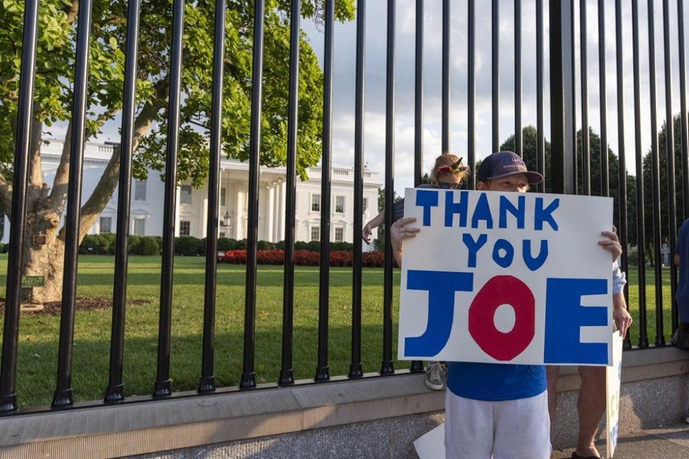 Hugh Kieve, 10, from Washington, holds a sign in front of the White House, Sunday, July 21, 2024, in Washington. President Joe Biden dropped out of the 2024 race for the White House on Sunday, ending his bid for reelection following a disastrous debate with Donald Trump that raised doubts about his fitness for office just four months before the election. (AP Photo/Alex Brandon)