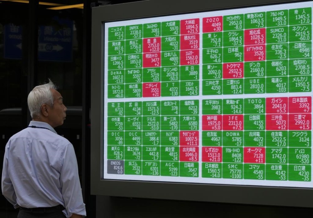 FILE - A passerby looks at an electronic stock board showing Japan's Nikkei 225 index at a securities firm in Tokyo, on June 27, 2024. Asian stocks were mostly lower Monday, July 22, 2024, after President Joe Biden exited the 2024 race. (AP Photo/Shuji Kajiyama, File)