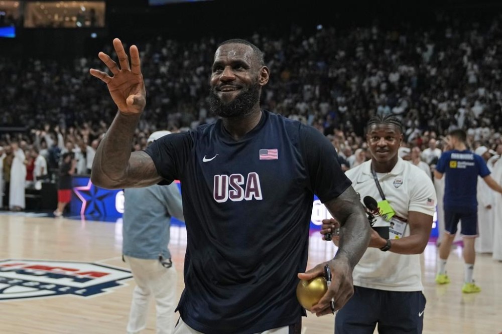 United States' LeBron James throws a signed golden ball after his team won an exhibition basketball match against Serbia at the USA Basketball Showcase, ahead of the 2024 Paris Olympic basketball tournament, in Abu Dhabi, United Arab Emirates, Wednesday, July 17, 2024. (AP Photo/Altaf Qadri)