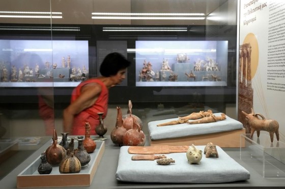 A woman passes behind antiquities repatriated from Germany and put on display at the Archeological museum, in capital Nicosia, Cyprus, on Monday. (Petros Karadjias / The Associated Press)