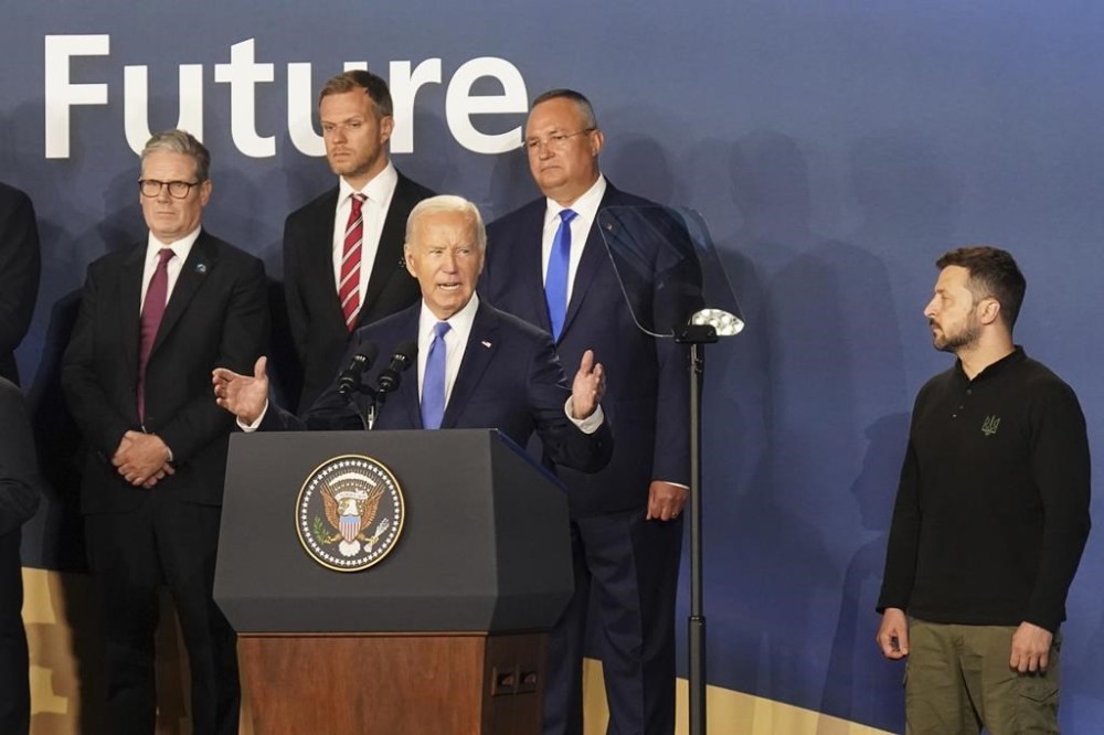 Britain's Prime Minister Sir Keir Starmer, left, and Ukrainian President Volodymyr Zelenskyy, right, look on as U.S. President Joe Biden speaks during an event on the Ukraine Compact at the NATO Summit at the Walter E. Washington Convention Center, in Washington, Thursday, July 11, 2024. Biden launched the Ukraine Compact, signed by 25 countries and the European Union, as part of a commitment to Ukraine's long term security. (Stefan Rousseau/Pool Photo via AP)