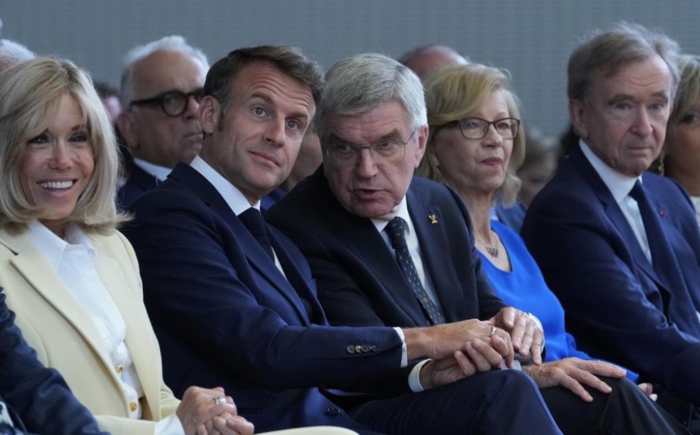IOC President Thomas Bach, center, French President Emmanuel Macron, center left, his wife Brigitte Macron, left, and LVMH CEO Bernard Arnault, right, sit, during the IOC Session Opening Ceremony at the Louis Vuitton Foundation ahead of the 2024 Summer Olympics, Monday, July 22, 2024, in Paris, France. (AP Photo/Thibault Camus)