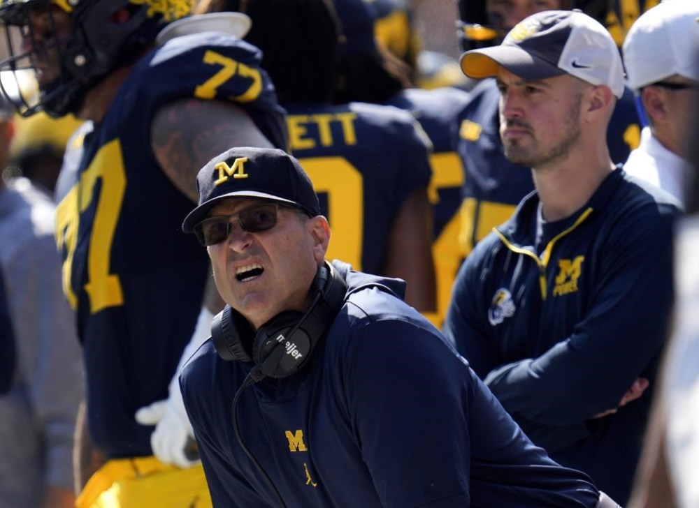 FILE - Michigan head coach Jim Harbaugh, front left, watches against Rutgers as analytics assistant Connor Stalions, right, looks on during an NCAA college football game in Ann Arbor, Mich., Sept. 23, 2023. Stalions is set to share his side of the story from an alleged sign-stealing scheme within Michigan’s football team before it went on to win the national championship. (AP Photo/Paul Sancya, File)