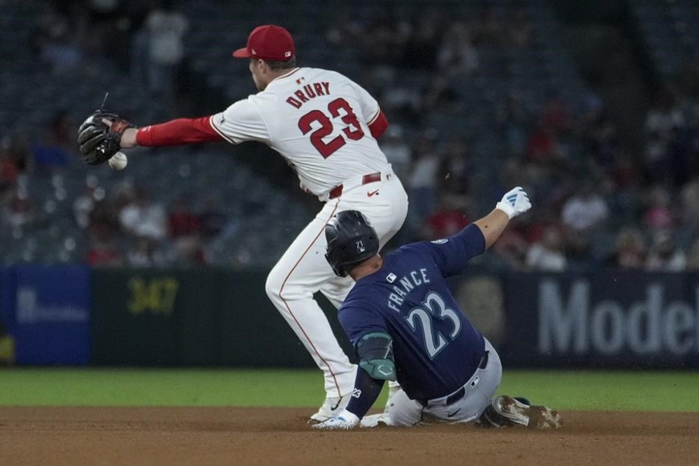 Seattle Mariners' Ty France (23) is forced out on a throw to Los Angeles Angels second baseman Brandon Drury (23) during the seventh inning of a baseball game in Anaheim, Calif., Thursday, July 11, 2024. (AP Photo/Eric Thayer)