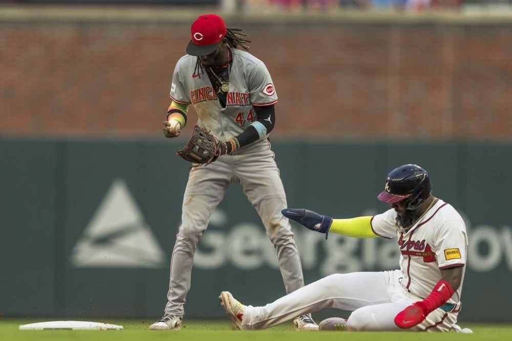 Cincinnati Reds shortstop Elly De La Cruz checks the ball as Atlanta Braves' Marcell Ozuna, right, slides into second base in the fourth inning of a baseball game, Monday, July 22, 2024, in Atlanta. (AP Photo/Jason Allen)