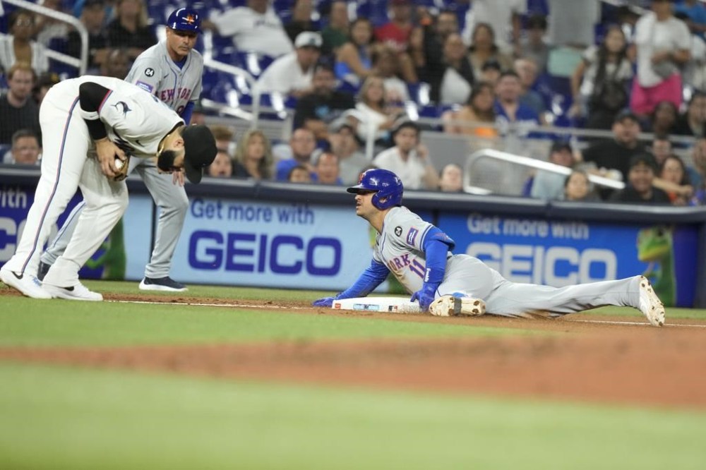 New York Mets' Jose Iglesias (11) beats the throw to Miami Marlins third baseman Emmanuel Rivera, left, for a triple during the fourth inning of a baseball game, Monday, July 22, 2024, in Miami. (AP Photo/Lynne Sladky)