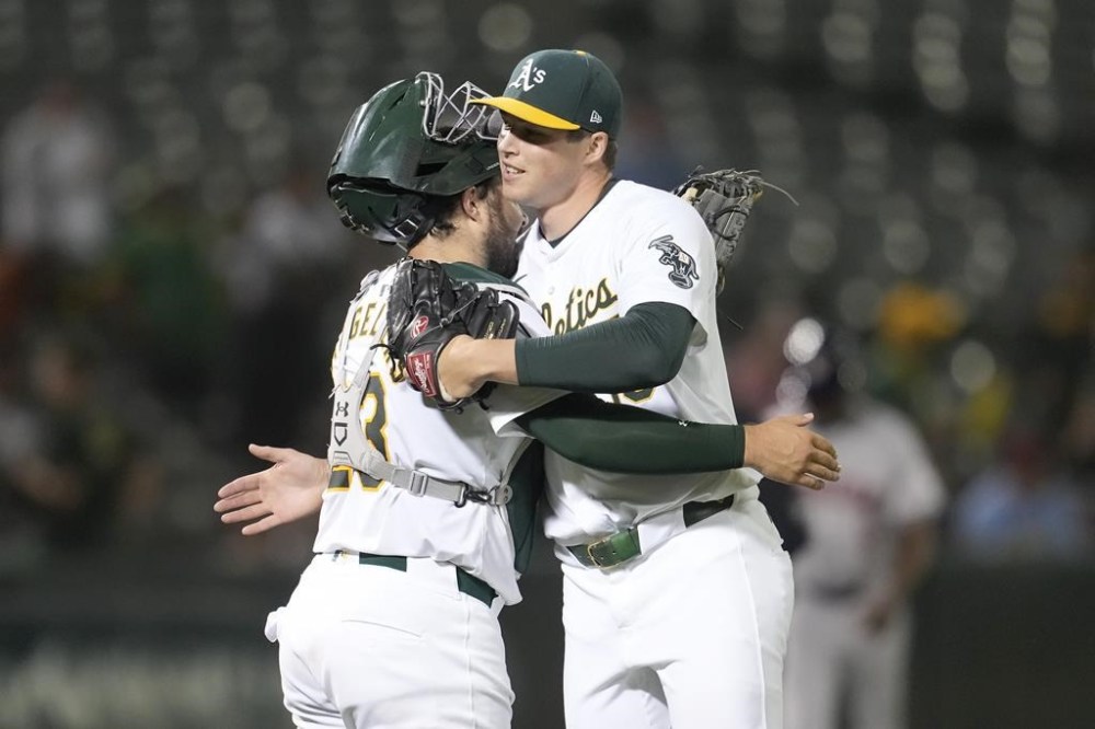 Oakland Athletics catcher Shea Langeliers, left, celebrates with pitcher Mason Miller after the Athletics defeated the Houston Astros in a baseball game in Oakland, Calif., Monday, July 22, 2024. (AP Photo/Jeff Chiu)