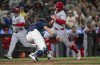 Los Angeles Angels' Brandon Drury, right, runs past Seattle Mariners catcher Cal Raleigh, center, to score a run during the ninth inning of a baseball game Monday, July 22, 2024, in Seattle. (AP Photo/Stephen Brashear)