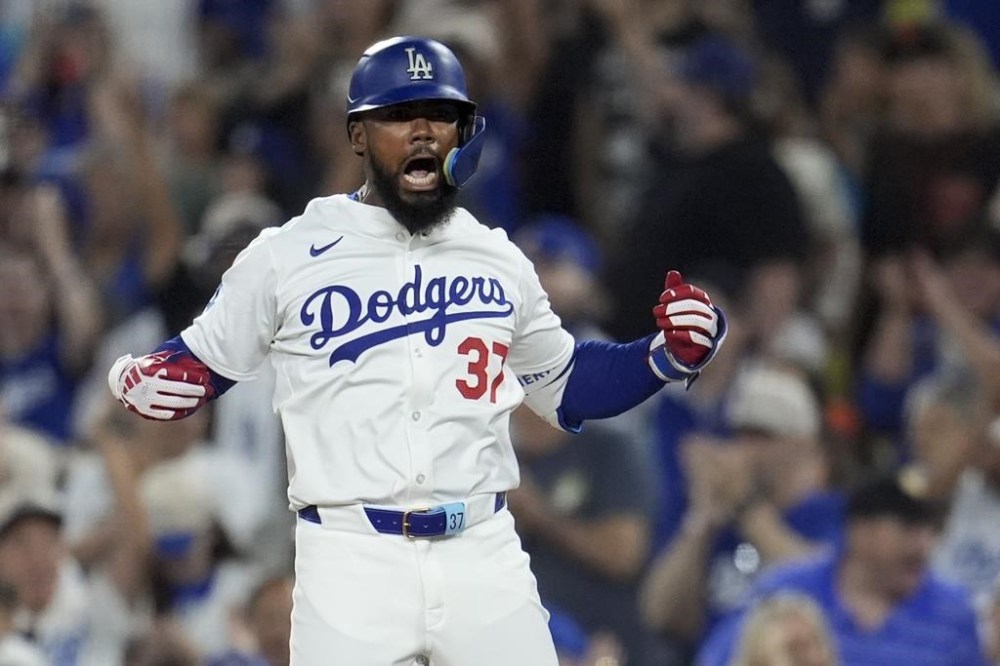 Los Angeles Dodgers' Teoscar Hernández reacts after at first base after hitting an RBI single during the eighth inning of a baseball game against the San Francisco Giants, Monday, July 22, 2024, in Los Angeles. (AP Photo/Marcio Jose Sanchez)