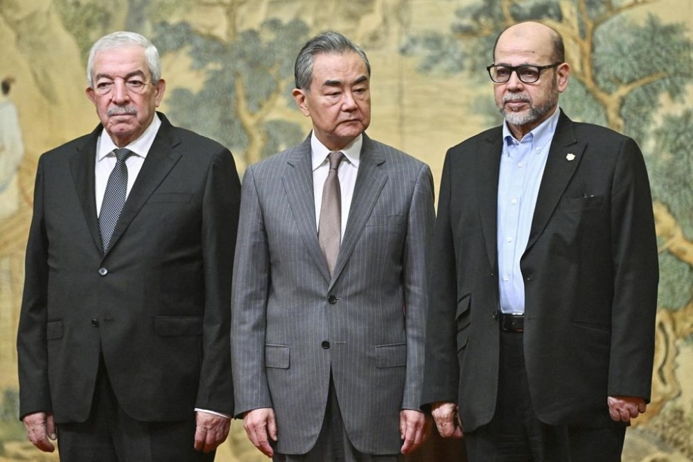 China's Foreign Minister Wang Yi, center, hosts an event for Mahmoud al-Aloul, left, vice chairman of Fatah, and Mussa Abu Marzuk, a senior member of Hamas, to meet at the Diaoyutai State Guesthouse in Beijing, Tuesday, July 23, 2024. (Pedro Pardo/Pool Photo via AP)