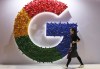 FILE - In this Nov. 5, 2018 file photo, a woman walks past the logo for Google at the China International Import Expo in Shanghai. Google is dropping plans to eliminate cookies from its Chrome web browser, making a sudden U-turn on four years of work to phase out the technology that tracks users for ad purposes. (AP Photo/Ng Han Guan, File)