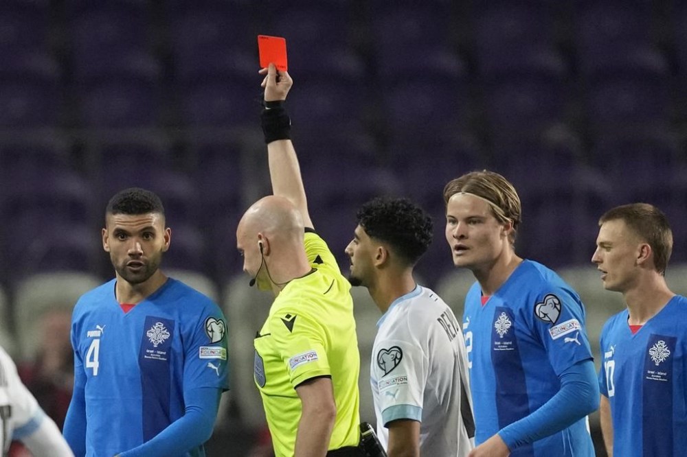 FILE - Israel's Roy Revivo receives a red card by referee Anthony Taylor during the Euro 2024 qualifying play-off soccer match between Israel and Iceland, at Szusza Ferenc Stadium in Budapest, Hungary, Thursday, March 21, 2024. The Olympic debut of Israel soccer player Roy Revivo on Wednesday, July 24, 2024 is on doubt until a sports court hearing in Paris hours before the game against Mali decides if he is banned. (AP Photo/Darko Vojinovic, File)