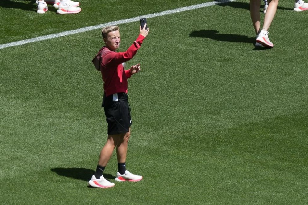Coach Beverly Priestman of Canada takes photos on the pitch at Geoffroy-Guichard Stadium ahead of the 2024 Summer Olympics, Tuesday, July 23, 2024, in Saint-Etienne, France. Canada is scheduled to play New Zealand on Thursday, July 25. (AP Photo/Silvia Izquierdo)