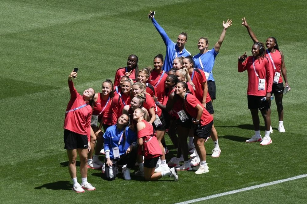 Canada's players pose for photos on the pitch at Geoffroy-Guichard Stadium ahead of the 2024 Summer Olympics, Tuesday, July 23, 2024, in Saint-Etienne, France. Canada is scheduled to play New Zealand on Thursday, July 25. (AP Photo/Silvia Izquierdo)