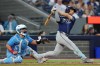 Tampa Bay Rays' Brandon Lowe (right) hits a two-run home run as Toronto Blue Jays catcher Alejandro Kirk looks on during fifth inning American League MLB baseball action in Toronto on Tuesday, July 23, 2024. THE CANADIAN PRESS/Chris Young