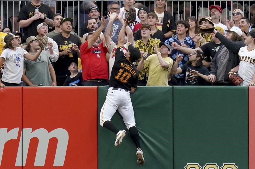 Pittsburgh Pirates left fielder Bryan Reynolds jumps for but can't reach a home run hit by St. Louis Cardinals' Nolan Arenado during the fifth inning of a baseball game Tuesday, July 23, 2024, in Pittsburgh. (AP Photo/Matt Freed)