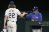 Texas Rangers' Jon Gray is greeted at the dugout entrance by pitching coach Mike Maddux after Gray threw to the Chicago White Sox in the sixth inning of a baseball game, Tuesday, July 23, 2024, in Arlington, Texas. (AP Photo/Tony Gutierrez)