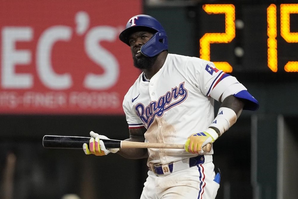 Texas Rangers' Adolis Garcia follows reacts after a swinging strike against the Chicago White Sox in the third inning of a baseball game, Tuesday, July 23, 2024, in Arlington, Texas. (AP Photo/Tony Gutierrez)
