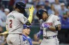Arizona Diamondbacks' Ketel Marte, right, dances at home plate as he is congratulated by Geraldo Perdomo (2) after hitting a two-run home run as Kansas City Royals catcher Freddy Fermin, center, looks on during the fifth inning of a baseball game in Kansas City, Mo., Tuesday, July 23, 2024. (AP Photo/Colin E. Braley)