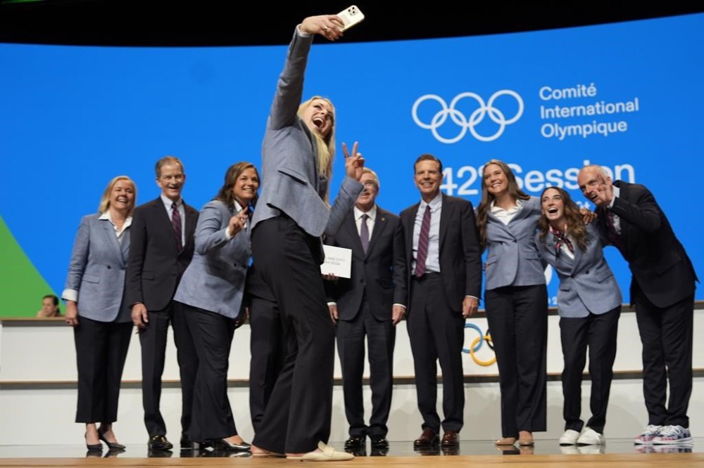 Former US skier Lindsey Vonn makes a selfie with the Salt Lake City delegation after Salt Lake City was named Olympics host again as the IOC formally awarded the 2034 Winter Games to the United States bid, at the 2024 Summer Olympics, Wednesday, July 24, 2024, in Paris, France. (AP Photo/David Goldman)