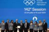 Utah Gov. Spencer Cox, fourth left, and IOC president Thomas Bach, center, pose with the Salt Lake City delegation during the 142nd IOC session at the 2024 Summer Olympics, Wednesday, July 24, 2024, in Paris, France, after Salt Lake City was confirmed as host for the 2034 Winter Games by International Olympic Committee. (AP Photo/Natacha Pisarenko)