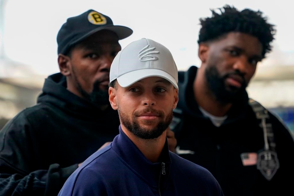 United States' Steph Curry, centre, Kevin Durant, background left, and Joel Embiid arrive at St Pancras Station with teammates, to take the Eurostar train as they make their way to the Olympic Games in Paris, in London, Wednesday, July 24, 2024.(AP Photo/Alberto Pezzali)