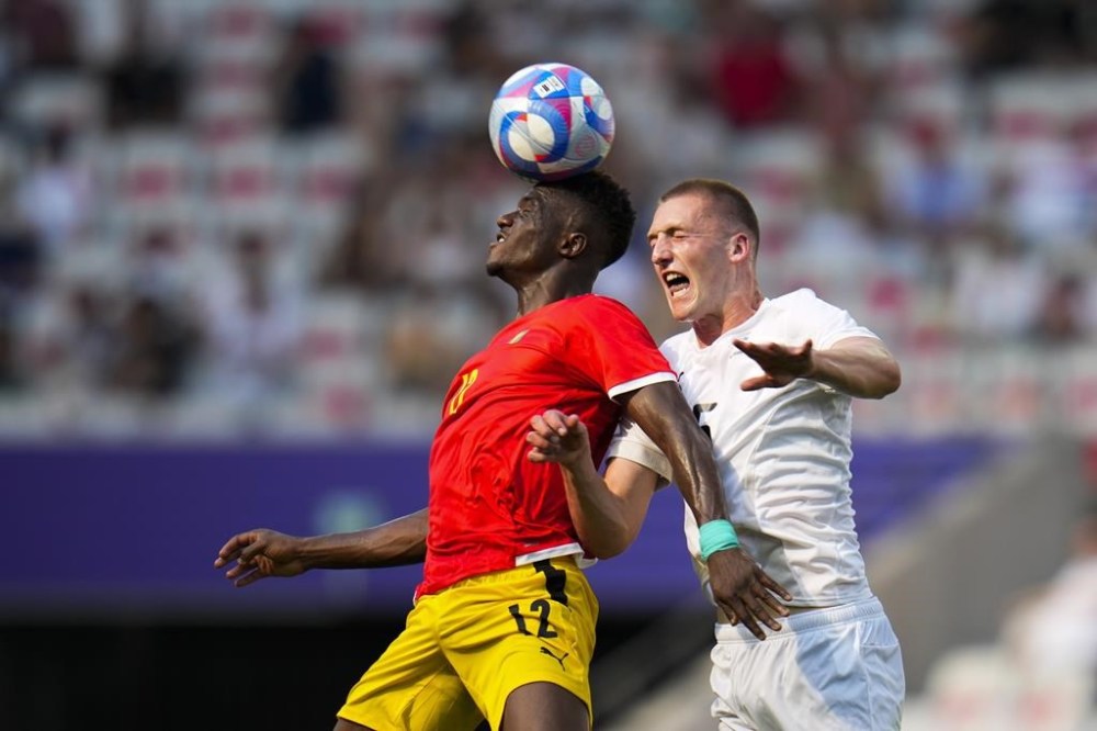 Guinea's Algassime Bah, left, and New Zealand's Finn Surman go up for the ball during a men's group A match between Guinea and New Zealand at Nice Stadium at the 2024 Summer Olympics, Wednesday, July 24, 2024, in Nice, France. (AP Photo/Julio Cortez)