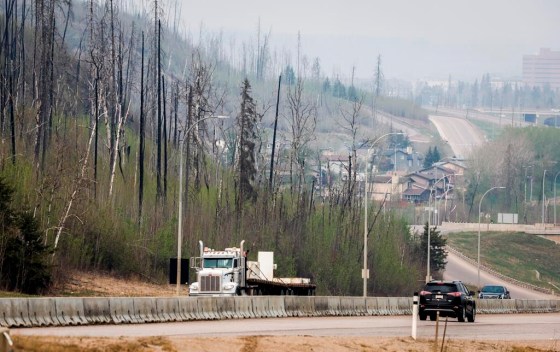 Traffic moves along Alberta Highway 63 as wildfire smoke hangs in air in Fort McMurray, Alta., in May. (Jeff McIntosh / The Canadian Press)