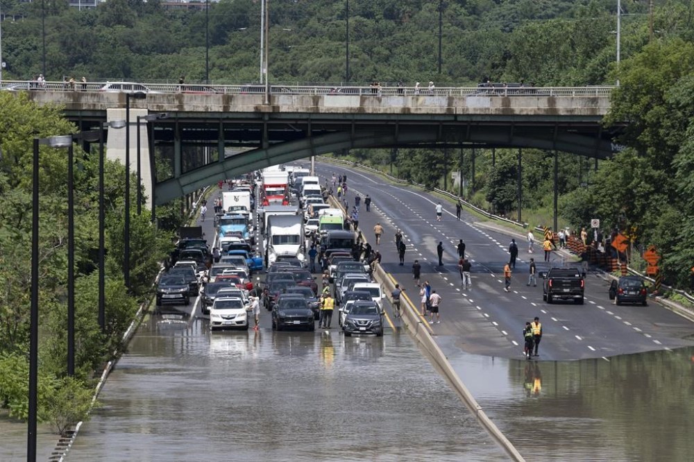 Drivers are stranded due to flood waters blocking the Don Valley Parkway following heavy rain in Toronto, on Tuesday, July 16 2024. Sections of Toronto roadways inundated by last week's storm have once again flooded after heavy rain drenched southern Ontario. THE CANADIAN PRESS/Arlyn McAdorey