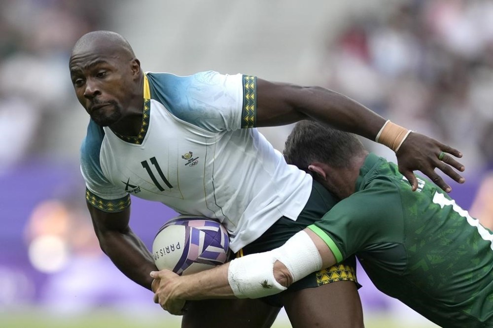 South Africa's Siviwe Soyizwapi, left, is tackled by Ireland's Jack Kelly during the men's Rugby Sevens Pool A match between Ireland and South Africa at the 2024 Summer Olympics, in the Stade de France, Saint-Denis, France, Wednesday, July 24, 2024. (AP Photo/Tsvangirayi Mukwazhi)