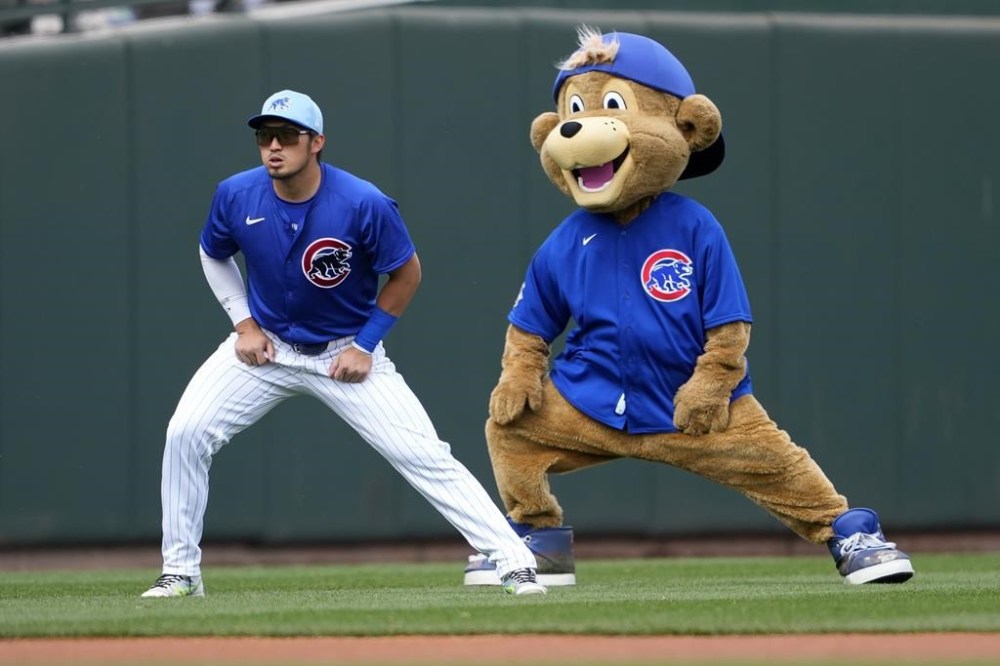 FILE. The Chicago Cubs mascot playfully stretches with Seiya Suzuki prior to a spring training baseball game against the Los Angeles Angels, Wednesday, March 6, 2024, in Mesa, Ariz. Stretching can help make you more flexible, improve range of motion in your joints — and feel good. (AP Photo/Matt York, File)