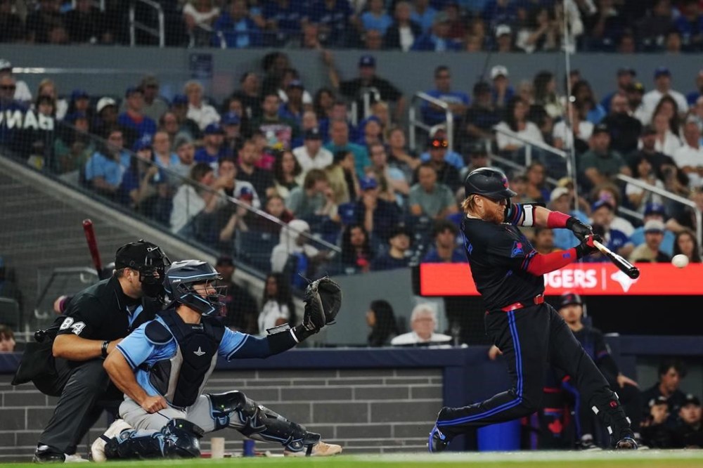 Toronto Blue Jays' Justin Turner (right) hits an RBI single as Tampa Bay Rays catcher Ben Rortvedt (30) looks on during eighth inning American League MLB baseball action in Toronto on Wednesday, July 24, 2024. THE CANADIAN PRESS/Chris Young