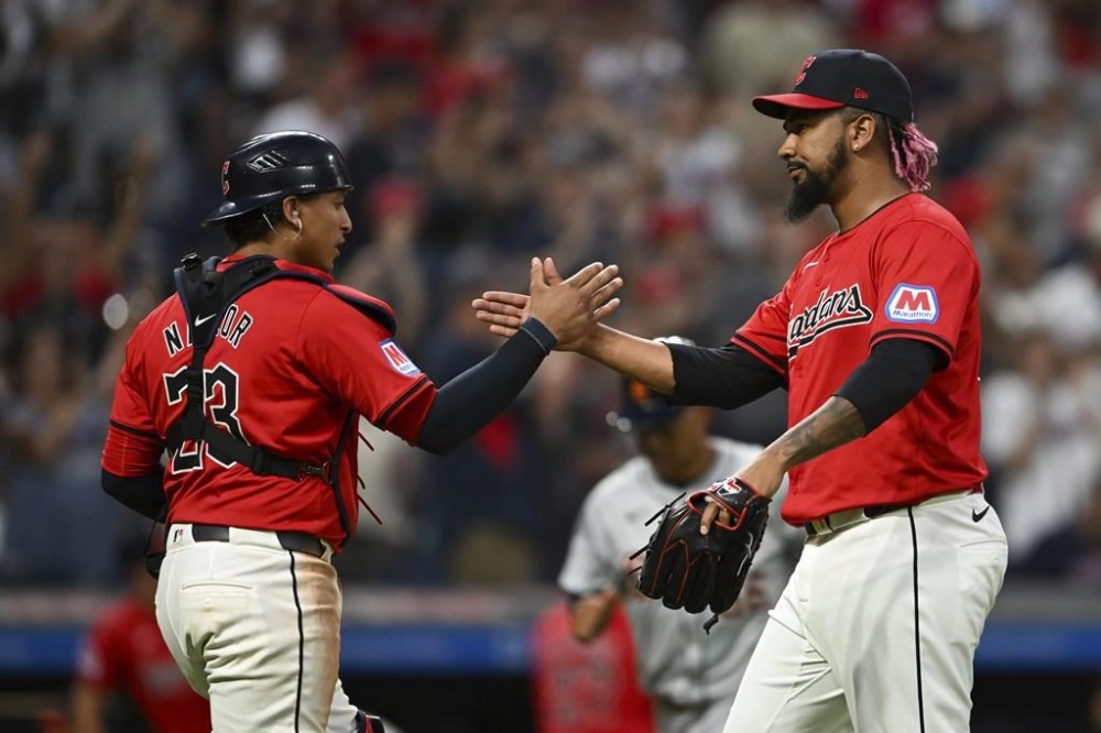 Cleveland Guardians' Bo Naylor (23) and relief pitcher Emmanuel Clase celebrate the team's 2-1 win over the Detroit Tigers in a baseball game, Wednesday, July 24, 2024, in Cleveland. (AP Photo/Nick Cammett)