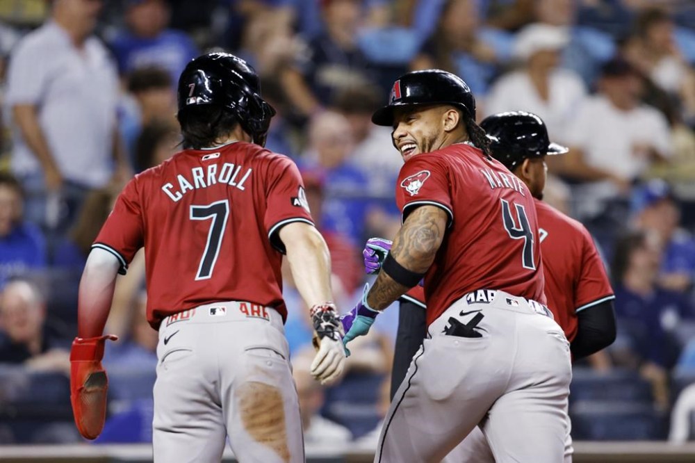 Arizona Diamondbacks' Ketel Marte (4) celebrates hitting a three-run home run with Corbin Carroll (7) during the ninth inning of a baseball game against the Kansas City Royals in Kansas City, Mo., Wednesday, July 24, 2024. (AP Photo/Colin E. Braley)