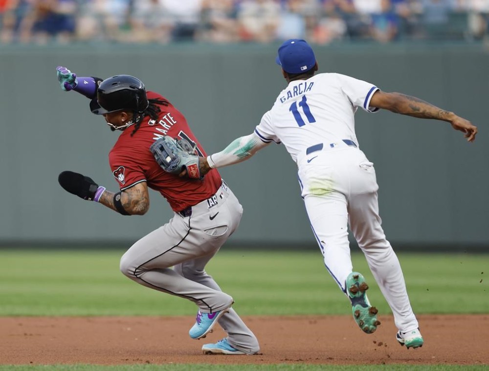 Arizona Diamondbacks' Ketel Marte (4) is tagged out by Kansas City Royals third baseman Maikel Garcia (11) after getting caught in a rundown between first and second base during the first inning of a baseball game in Kansas City, Mo., Wednesday, July 24, 2024. (AP Photo/Colin E. Braley)