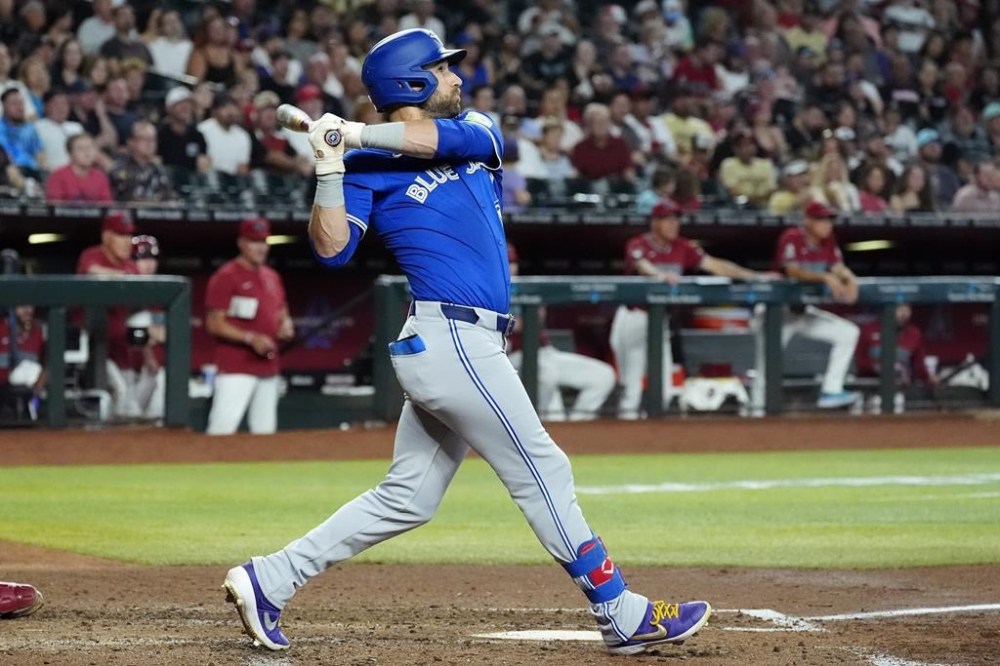 Toronto Blue Jays' Kevin Kiermaier watches the flight of his grand slam against the Arizona Diamondbacks during the fourth inning of a baseball game, Sunday, July 14, 2024, in Phoenix. (AP Photo/Ross D. Franklin)