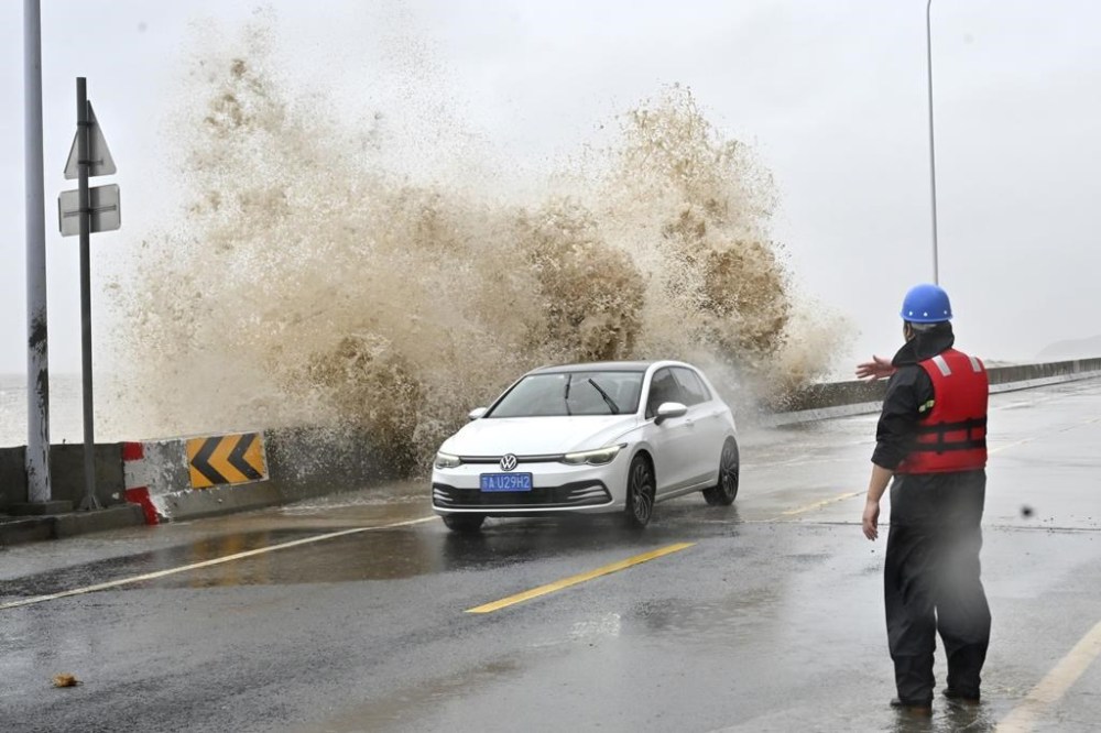 In this photo released by Xinhua News Agency, a car passes as waves lash the shore ahead of landfall by Typhoon Gaemi in Sansha Township of Xiapu County, southeast China's Fujian Province, Thursday July 25, 2024. After hitting Philippines and Taiwan, the storm's effects were expected to continue into Friday as it moved in a northwestern direction toward mainland China. In Fujian province on China's east coast, ferry routes were suspended on Wednesday and all train service will be halted on Thursday, China's official Xinhua News Agency said. (Jiang Kehong/Xinhua via AP)