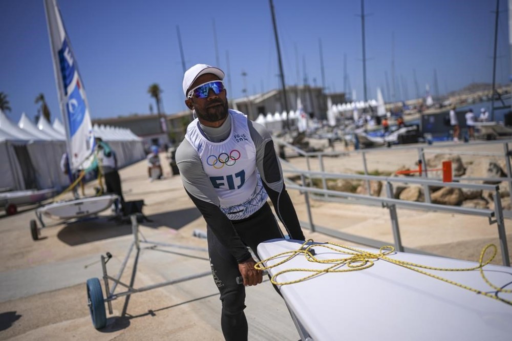 CORRECTS SPELLING OF FIRST NAME TO VILIAME NOT VILIAM - Fiji's Viliame Ratulu, competing in the men's dinghy sailing competition, prepares his dinghy for a practice session at the Marseille Marina during the 2024 Summer Olympics, Thursday, July 25, 2024, in Marseille, France. (AP Photo/Daniel Cole)