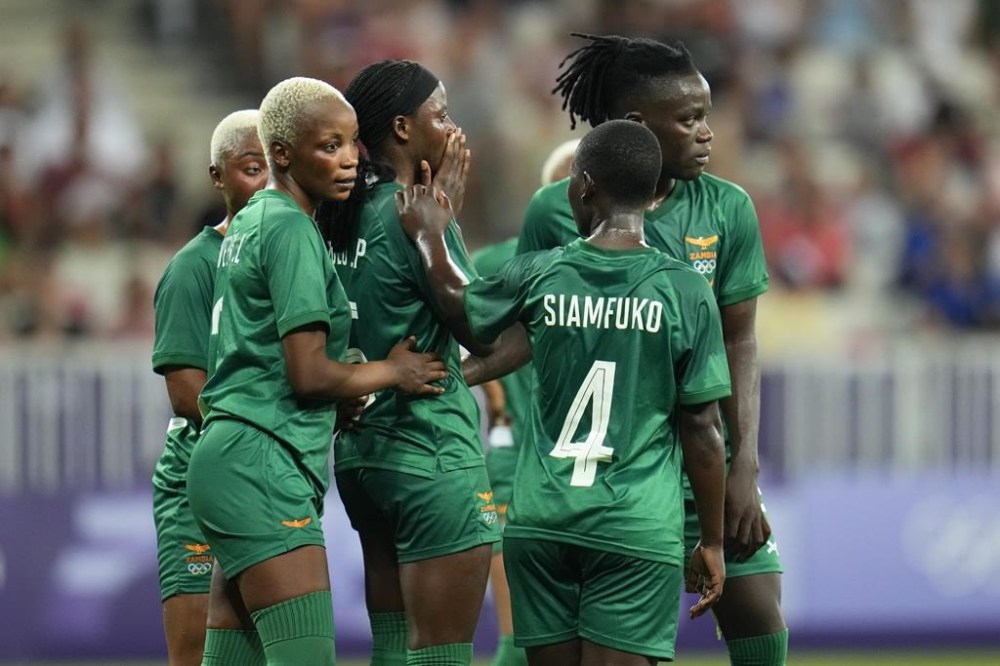Zambia athletes gather around Pauline Zulu, center, after she was given a red card by referee Ramon Abatti, of Brazil, during a women's group B match between the United States and Zambia at Nice Stadium at the 2024 Summer Olympics, Thursday, July 25, 2024, in Nice, France. (AP Photo/Julio Cortez)