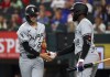 Chicago White Sox Brooks Baldwin (27) slaps hands with Luis Robert Jr. (88) after scoring against the Texas Rangers in the third inning of a baseball game Thursday, July 25, 2024, in Arlington, Texas. (AP Photo/Richard W. Rodriguez)