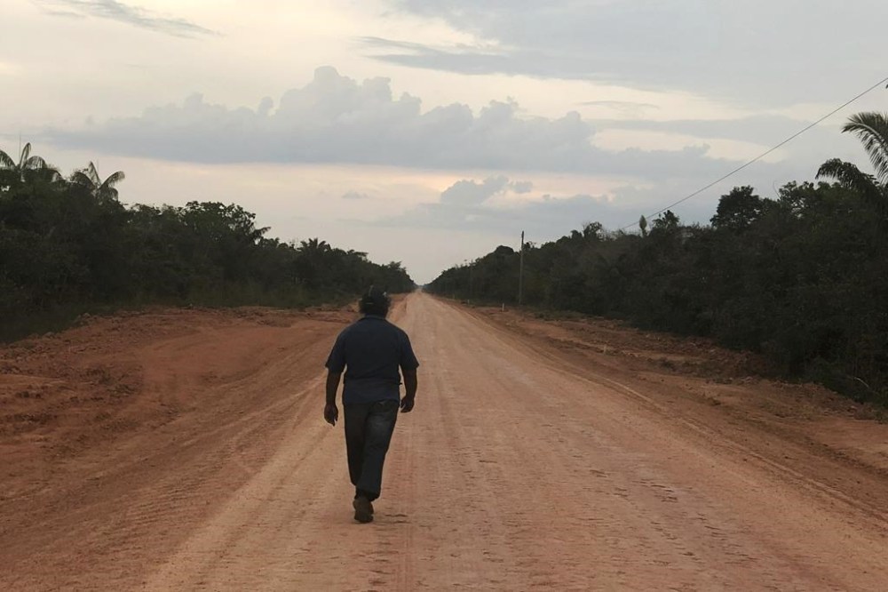 FILE - A man walks down an unpaved stretch of highway BR-319 in the Brazilian Amazon between the cities of Manaus and Porto Velho on Aug. 10, 2018. A Brazilian federal court on July 24, 2024, halted progress on the project paving this dirt highway that connects the major city of Manaus with populous regions, citing the likelihood it will contribute to climate change. (AP Photo/Fabiano Maisonnave, File)