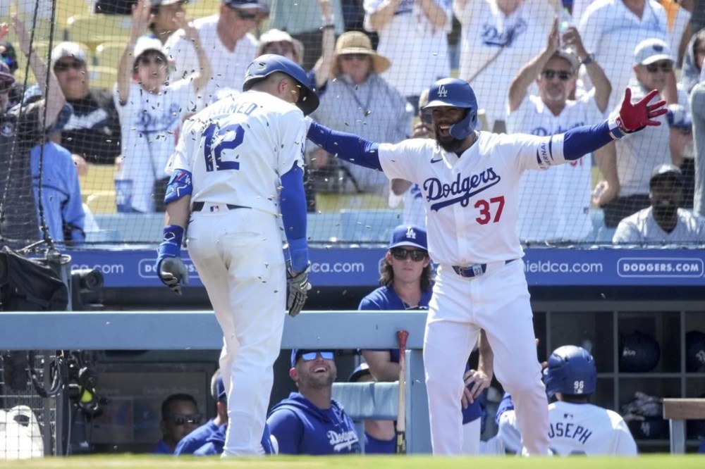 Los Angeles Dodgers' Teoscar Hernandez (37) congratulates teammate Nick Ahmed (12) for hitting a home run during the eighth inning of a baseball game against the San Francisco Giants in Los Angeles, Thursday, July 25, 2024. (AP Photo/Eric Thayer)