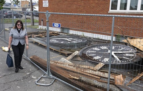 Rev. Edwina Landry, Pastor of the First Presbyterian Church of Rome, walks past salvaged steeple clock faces recovered from the destroyed steeple of the church in Rome, N.Y., Tuesday, July 23, 2024. Cleanup continues around the heavily damaged city center after the EF2 tornado touched down one week earlier. (AP Photo/Craig Ruttle)