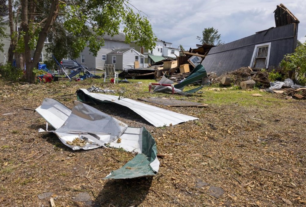 Debris and crushed outbuildings rest behind heavly damaged and destroyed homes along Henry Street in South Rome, N.Y., Tuesday, July 23, 2024, following an EF2 tornado that touched down in the population center one week earlier. Residents are vowing to rebuild. But some of the damage was so severe that the path forward is uncertain for many in this old manufacturing city, where people are more accustomed to digging out from snowstorms than from piles of rubble. (AP Photo/Craig Ruttle)