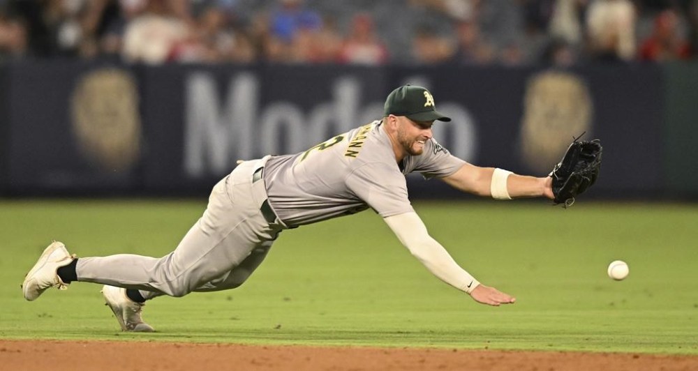 Oakland Athletics shortstop Max Schuemann cannot catch a ball hit by Los Angeles Angels' Kevin Pillar during the sixth inning of a baseball game Thursday, July 25, 2024, in Anaheim, Calif. (AP Photo/John McCoy)