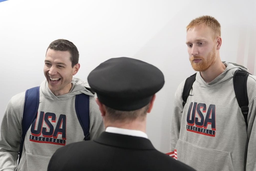 Team USA basketball athletes, Mitch Hahn, right, and Jimmer Fredette, talk with people before departing for the Paris Summer Olympic games, on Wednesday, July 17, 2024, in Atlanta. (AP Photo/Brynn Anderson)