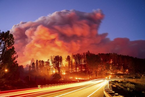 Seen in a long exposure photograph, the Park Fire burns along Highway 32 in the Forest Ranch community of Butte County, Calif., on Thursday, July 25, 2024. (AP Photo/Noah Berger)
